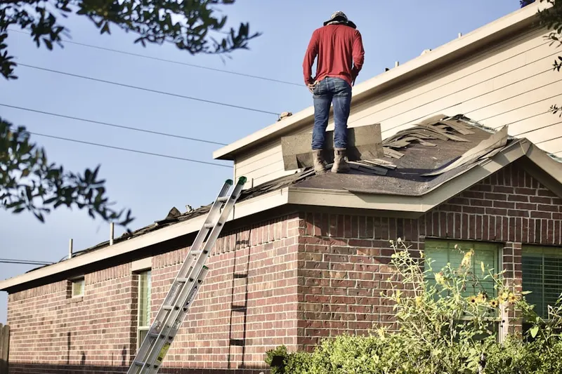 Professional roofer working on a residential roof in Autumn Chase Apartments